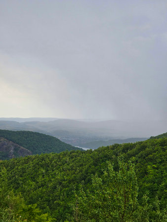 Gilau Lake seen from the top of the Somesul Cald mountain over green forest hills on a cloudy summer day. Cluj, Romaniaの写真素材