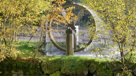 Water wheel behind bushes at Scheidegger Waterfalls Germany