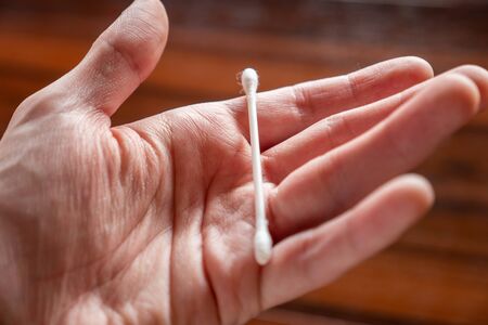 Hand holding a cotton swabの写真素材