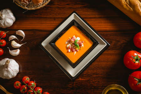 Typical spanish recipe for cordovan salmorejo in a square plate with some ingredients aroundの写真素材