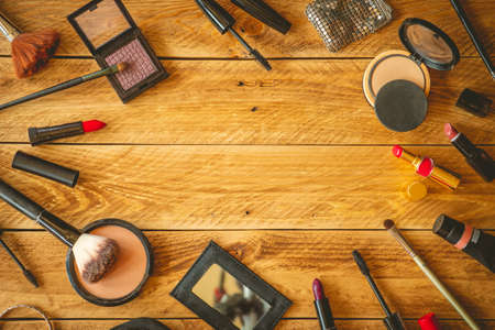 Makeup products on a wooden table with copy space in the middle.の写真素材