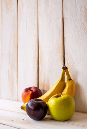 White wooden wall with a small group of fresh ripe fruits and copy spaceの写真素材