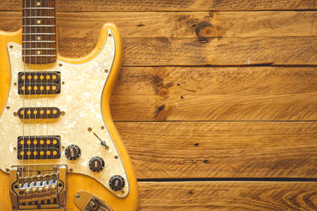 Beautiful vintage electric guitar on a brown wooden table, with copy space.
