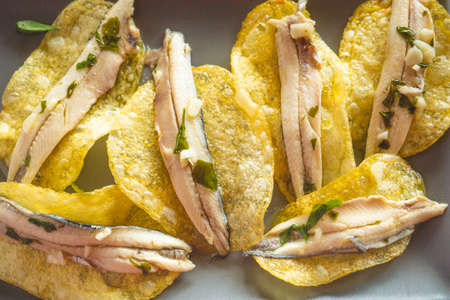 Potato chips with pickled anchovies. Typical Spanish food to eat in a bar.の写真素材