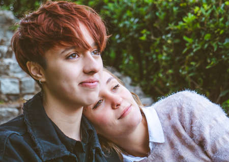 Girls couple in love relaxing on the stone stairs in a park.の写真素材