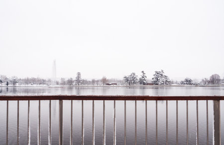 View to the lake of the âCasa de Campoâ park in Madrid, from the railing, with the horizon covered by snow, during âFilomenaâ storm.の写真素材