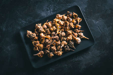 Mollusks called âCaÃ±aillasâ cooked in a black rectangular plate on a dark table. Typical food of AndalucÃ­a, Spain. Easy seafood recipe. Photo with selective focus.の写真素材