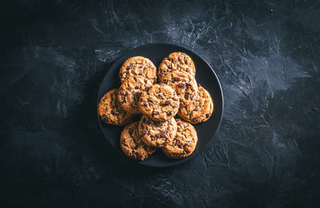 Homemade chocolate chip cookies on a black plate on a dark table. Ready to eat.の写真素材