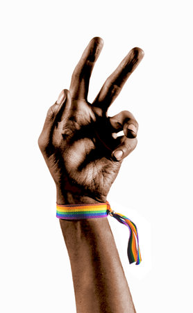 Raised black arm wearing a bracelet with the colors of the LGBT flag. LGBT symbol.の写真素材