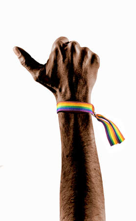 Black hand wearing a bracelet with the colors of the LGBT flag raising thumb. LGBT symbol.の写真素材