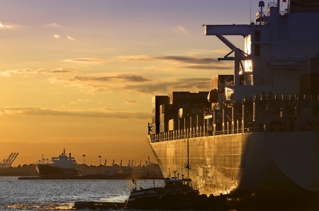 Golden sun beams lighten a cargo-ship in Manhattan Bayのeditorial素材