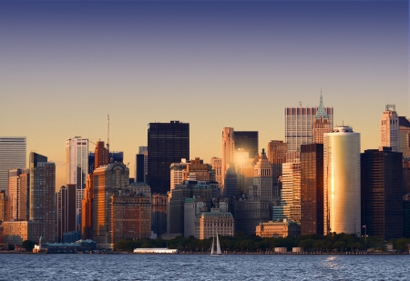 The last sun beams of the day reflect on the glass skyscrapers of Manhattanの写真素材