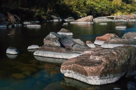 Big stones into the river at sunset. Long exposure. Colourの写真素材