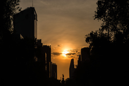 Silhouette of Mexico City against an orange sky as seen from a low angle viewの写真素材