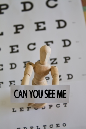 Wood doll with sign saying can you see meの写真素材