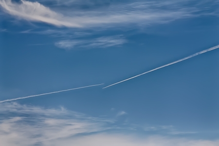 Aircraft contrails against the blue sky on a clear winter dayの写真素材