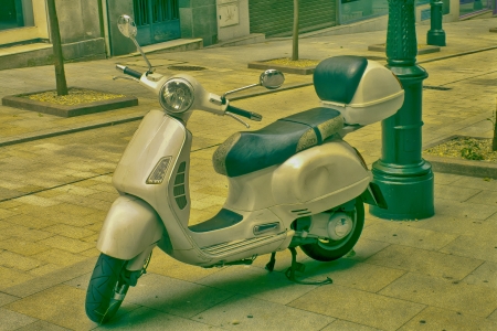 Scooter parked in a typical city street in vintage coloursの写真素材