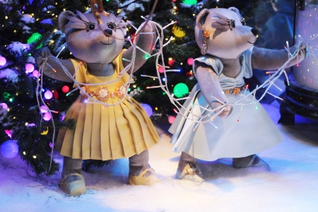 teddy bear playing in the snow in front of some christmas treesの写真素材