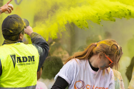 Madrid, Spain, Athletes running in a race with colored powders through the streets of Madrid against...