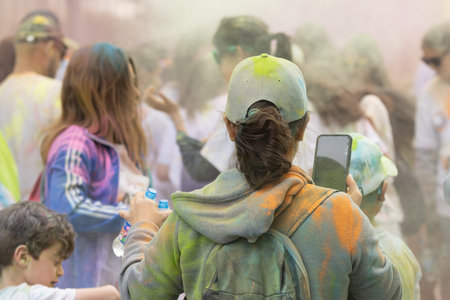 Madrid, Spain, Athletes running in a race with colored powders through the streets of Madrid against...
