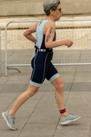 Madrid, Madrid, Spain; 06/04/2023: older woman runs in a triathlon event through the streets of Madridのeditorial素材