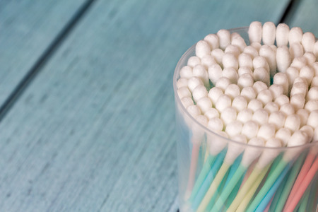 Plastic cotton swabs in package. Blue background. Cotton swabs are on the war on plastic. There are plans to ban the sale of cotton swabs to help reduce pollutionの写真素材