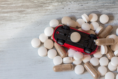 Driving under the influence of drugs. Pills and overturned carの写真素材