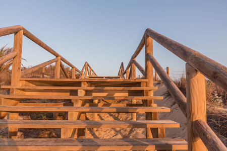 Walkway between sand dunes under blue sky (Mediterranean beach)の写真素材