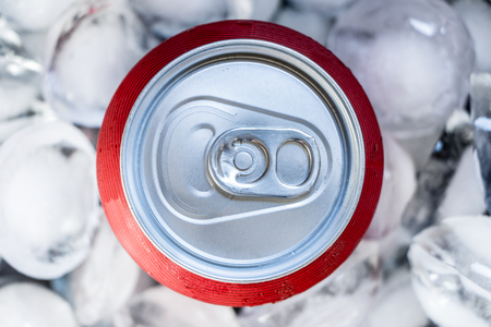 Red can in ice cubes. Cold drink concept
