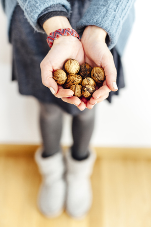 Close up of a woman's hands holding walnutsの写真素材