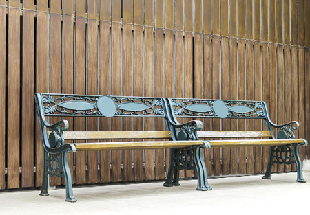 Two green bench and brown wooden pattern backgroundの写真素材