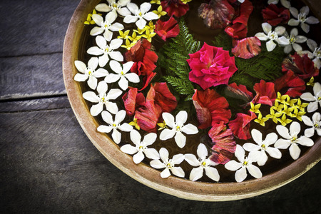 Spa therapy with flowers on  water in bowl   and wooden background