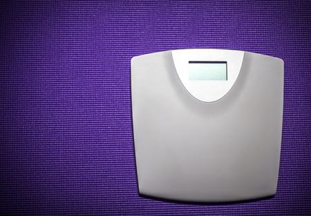 Digital weight scale on purple carpet backgroundの写真素材