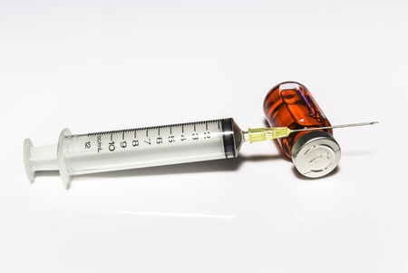 Needle and injection in bottle on white backgroundの写真素材