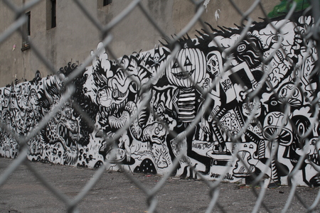 Black and white graffiti in New York behind a metal netのeditorial素材