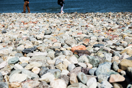 Rocky coast in Landudno , England, UK and kids playing near waterの写真素材