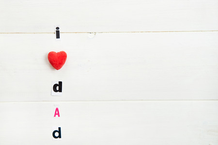 I Love Dad Letters Cut out from Magazine with Red Heart laying on White Wooden Backgroundの写真素材