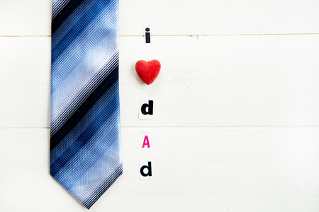 I Love Dad Letters Cut out from Magazine with Blue Tie laying on White Wooden Backgroundの写真素材