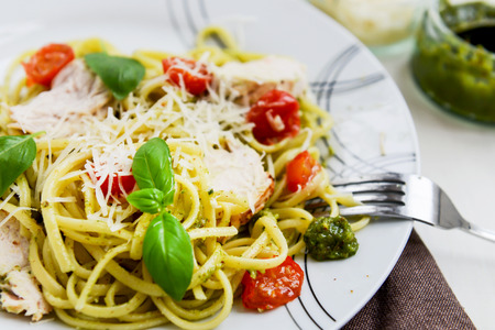 Linguine Pesto with Parmesan, Lemon Chicken, and baked baby plum tomatoesの写真素材