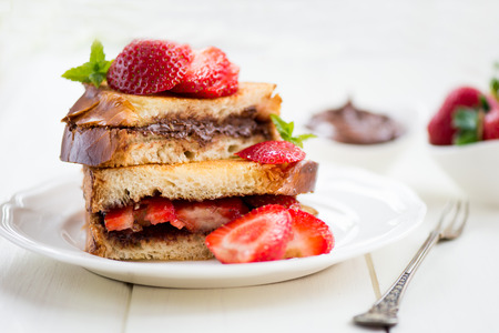 French Toasts with Chocolate Hazelnut Filling and Strawberries on White Plate, with Small Bowls with Strawberries and Chocolate Paste nearbyの写真素材