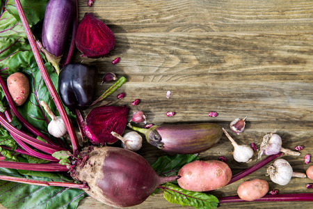 Collection of Freshly Harvested Purple Organic Homegrown Vegetables such as Beetroot, Garlic, Aubergine, Lettuce, Red Potato, Black Pepper, Beans, on the Rustic Wooden Background with Top View, shallow DOF, selective focusの写真素材