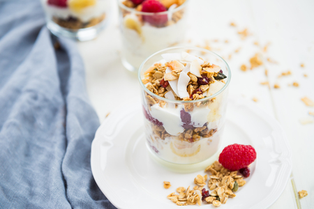 Healthy Energy-boosting Breakfast made from Homemade Nut and Seeds Granola, Yogurt, Raspberries, Banana and Maple Syrupの写真素材