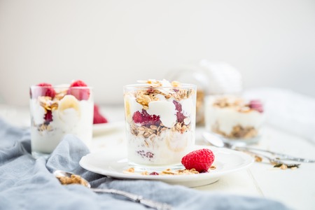 Healthy Energy-boosting Breakfast made from Homemade Nut and Seeds Granola, Yogurt, Raspberries, Banana and Maple Syrupの写真素材