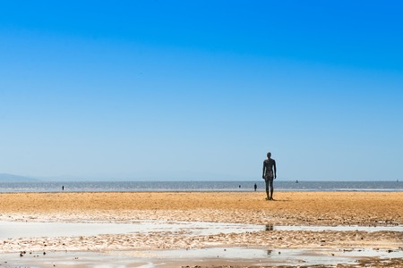 CROSBY BEACH, ENGLAND - MAY16, 2016: Sculpture on Crosby Beach forming part of the Another Place modern art installation by Anthony Gormley の写真素材