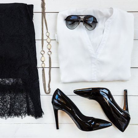 Woman Trendy Fashion Accessories such as Court Shoes, Silk Blouse, Lace Skirt, Necklace, Sunglasses, Make Up and Jewellery on White Wooden Background, Flat Lay, Top Viewの写真素材
