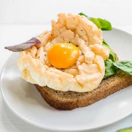 Healthy Breakfast with Wholemeal Bread Toast and Cloud Egg with Green Salad and Avocado. Egg in Clouds is an oven dish, when the egg white and egg yolks are cooking separately.の写真素材