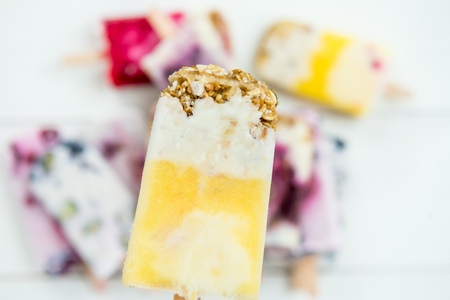Homemade Vegan Mango  ice pop with Granola, Mango Juice and Coconut Milk on light background. Summer food concept. Top view. Copy space for textの写真素材