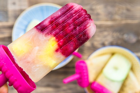 Homemade Vegan Popsicle from Frozen Apple Juice and Berries, Apples and Cookies on Dark Rustic background. Summer food concept. Top view. Copy space for textの写真素材