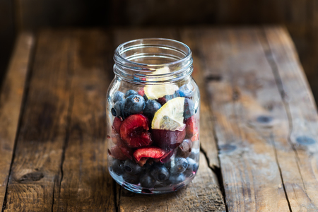 Ingredients for Summer Slushy from Blueberries, Cherries, Lemon and Ice in the Jar, on dark rustic backgroundの写真素材