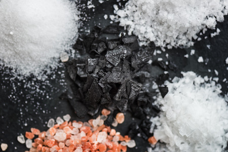 Different Kinds of Salt in Spoons, such as Himalayan Pink, Sea Original, Iodised Table, Sea Salt Flakes, Pink Diamonds, Black Sea Flakes, on Dark Backgroundの写真素材